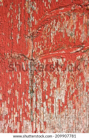 A background of old red wooden barn boards with peeling paint on the exterior of a barn.