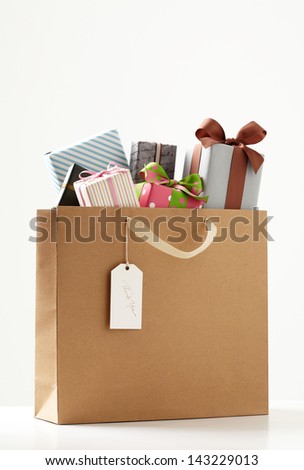 Shopping Bag of presents on white table.  brown Shopping bag.