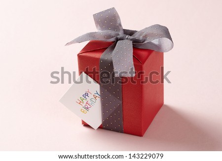 red gift box on pink background. red Gift box with gray ribbon.