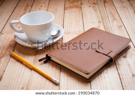 Coffee cup with notebook and pencil