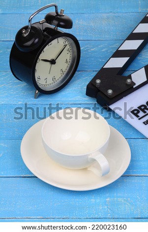 Blank movie clapper board with coffee cup and clock, slate film.