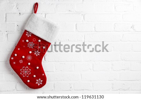 Red Christmas sock hanging on white brick wall