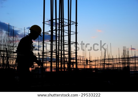 Builder Silhouette at Construction Site at Dusk