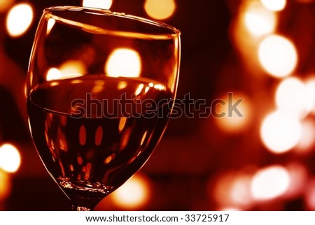 Close up on Glass of Red Wine with Lights Background.