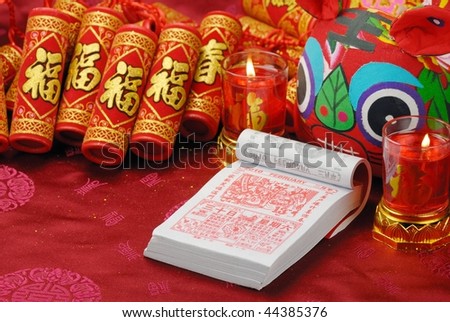 Chinese New Year's Eve--Traditional lunar calendar(Showing last day of 2009) , firecrackers and cloth tiger,2010 is year of tiger.