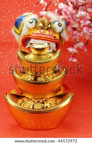 A traditional lion bites a stack of gold ingots,the lion is believed to be able to dispel evil and bring good luck and prosperity in China.