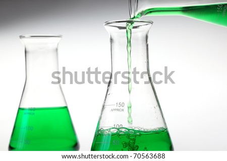 Pouring liquid chemicals into flask .