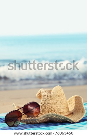 Concept of summer holidays with straw hat and sunglasses on sandy beach