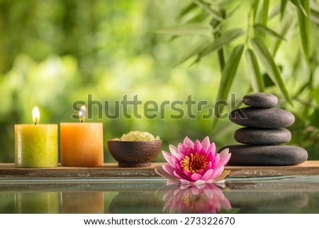 Spa still life with burning candles,zen stone and salt reflected in a serenity pool