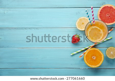 Healthy juice and fresh fruits on wood background