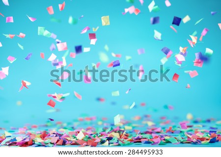 Colored confetti flying on blue background