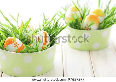 Easter eggs with fresh grass on table.