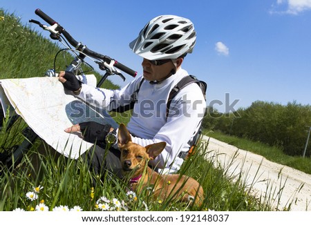 mant with dog and mountain bike check the map to find your way