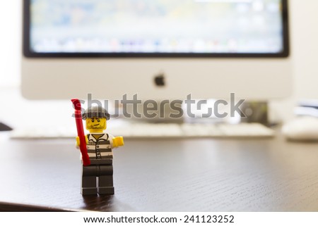 Orvieto, Italy - December 27th 2014: Lego mini figure thief on apple computer. Lego is a popular line of construction toys manufactured by the Lego Group