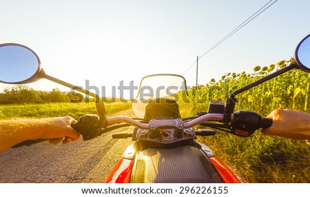 riding the bike along a country road in a sunset, sunflowers. POV Original Point o view. HDR image.