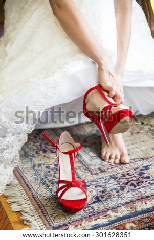 Red shoes for young bride in white dress
