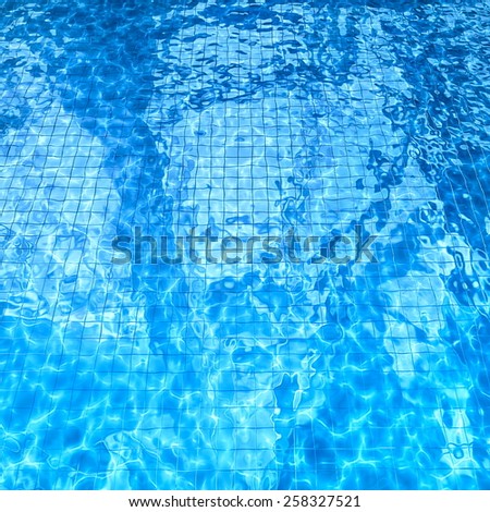 swimming pool with sun glare and optical caustic network on the water