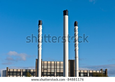 Industrial chimney stacks against a clear blue sky