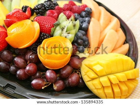Variety of fruit on a plate includes strawberry, grapes, blueberries, blackberries, kiwi, melon, raspberry, mango,tropical, juicy, fresh, healthy