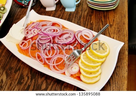 Platter of smoked salmon, sliced red onion, sliced lemon