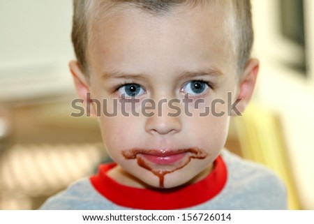 Toddler boy with dripping chocolate mouth