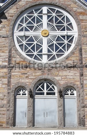 Round window and 3 arched doors of old heritage church