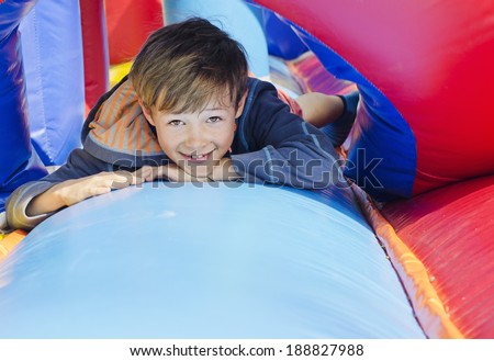 Cute young boy lying down on a bouncy castle