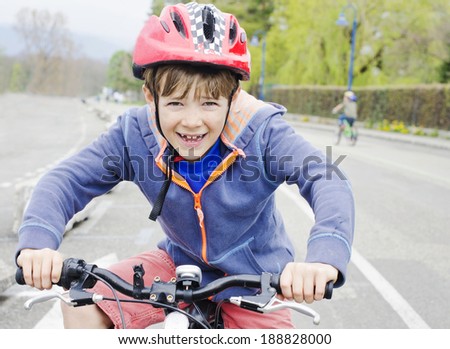 Cute young boy gripping the handle bars of his bike