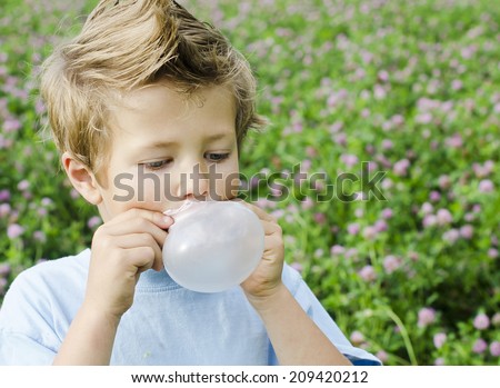 Cute young boy blowing bubble gum