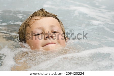 Cute young boy swimming in a hot tub
