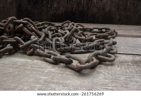 Old grunge chains. Old grunge metal chains laying on a wooden grunge table composition.