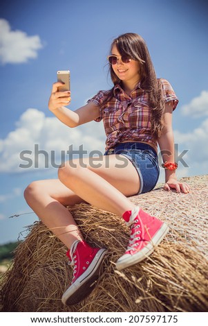 Beautiful teen girl on hay roll
