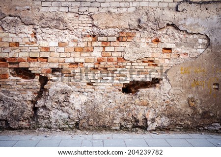 Old weathered wall of bricks and a ground