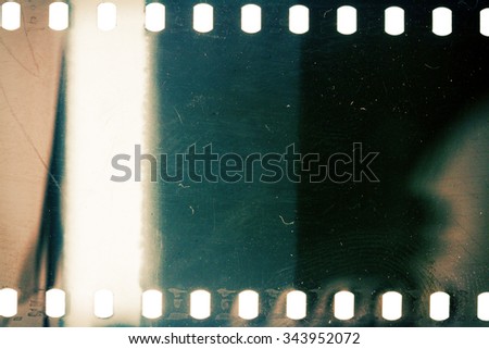 Blank grainy film strip texture background with lots of dust, noise and light leak