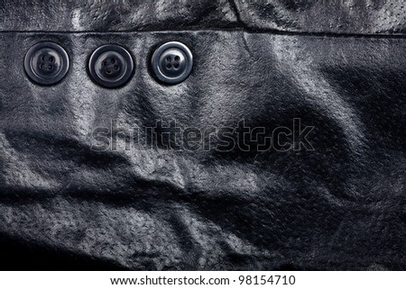 Fragment of black leather jacket with some buttons