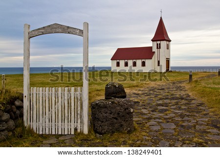 Small church building in Iceland with white wooden gate