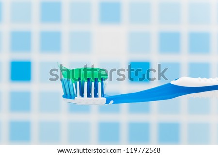 toothbrush against blue tile background
