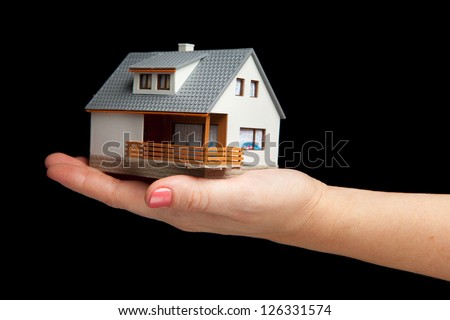 hand holding house, isolated on black