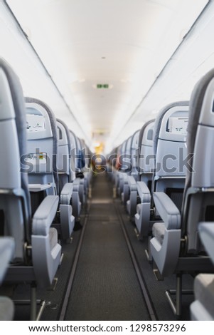airline passenger seats and aisle in airplane cabin