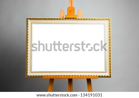 easel with painting frame on grey background