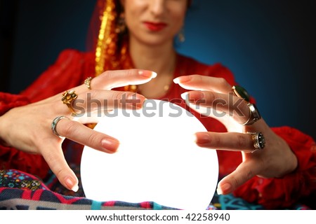 hands of a fortune-teller working with a shining crystal ball