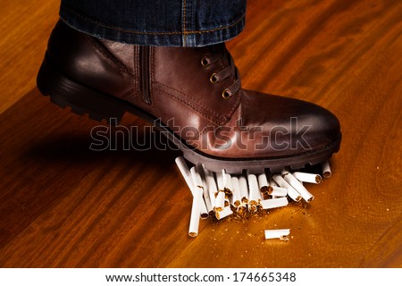 shoes trampling down on cigarettes - give up smoking concept
