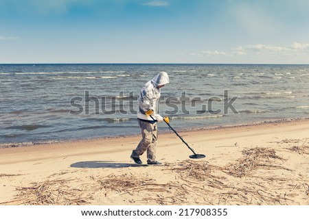 man searching for a precious metal using a metal detector