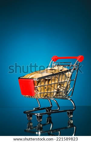 shopping cart full of money, blue background