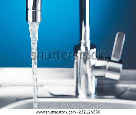 mixer tap with flowing water, closeup view