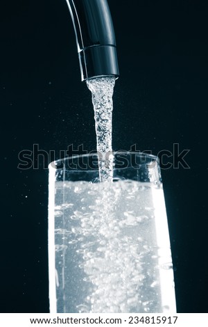 pouring a glass of water from mixer tap
