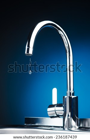 mixer tap with water drops, blue background