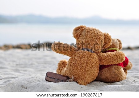 Teddy bears sitting on the beautiful beach with love. Concept about love and relationship.