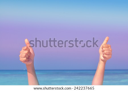Two hand making the sign of Like with the blue sea and sky background (Vintage Style)