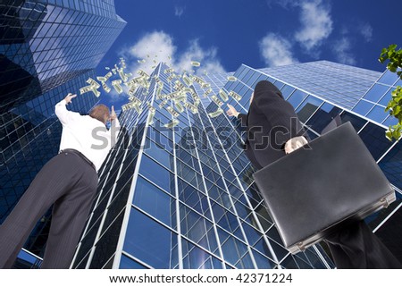 business people reaching for money falling from the sky